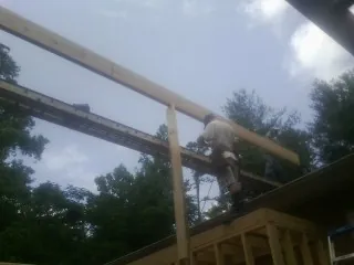 Carpenter setting a ridge beam over a new addition frame — Ice Dam Removal by Roofing Brothers in Havre De Grace