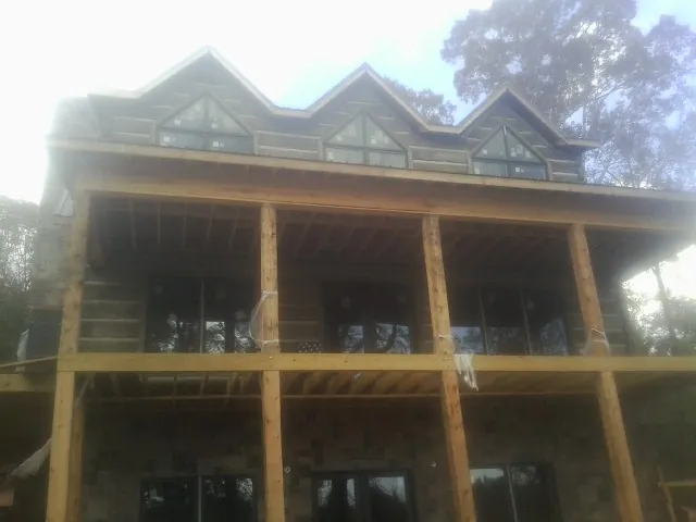 Dormers and porch framing on a large log home under construction — Roof Coating work by our crew in Havre De Grace