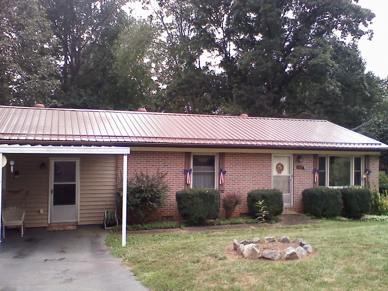 Bronze metal roof and carport on a brick ranch home — Roof Repair work by our crew in Havre De Grace